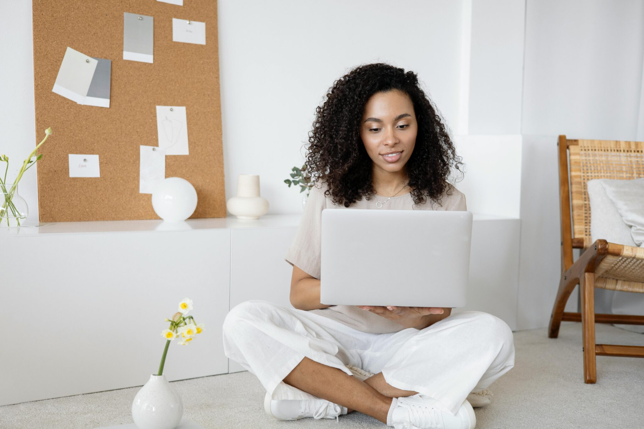 A woman sitting on the floor with her laptop.